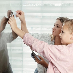 A woman and a child are holding up a photo of themselves, capturing a moment together.