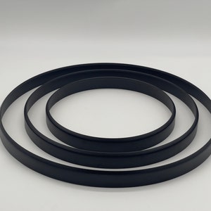 Op de afbeelding: Drie zwarte ronde frames van verschillende groottes, in elkaar genest.