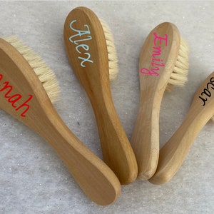 Puede incluir: Cuatro cepillos de pelo de madera con diferentes nombres escritos en ellos. Los nombres son "Hannah", "Alex", "Emily" y "Oscar".
