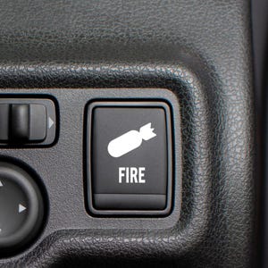 May include: A black button with a white icon of a fire extinguisher and the word "FIRE" in white text.