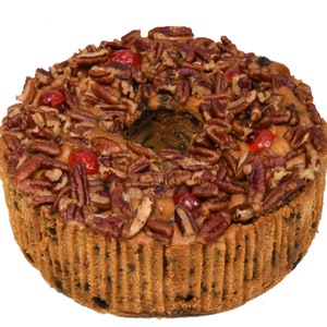 May include: A round fruitcake topped with pecans and red maraschino cherries.