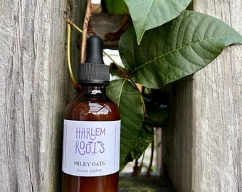 May include: A brown glass dropper bottle with a black cap and a white label. The label features the text HARLEM ROOTS in purple, followed by MILKY OATS and Avena sativa in black text. The bottle is positioned upright.