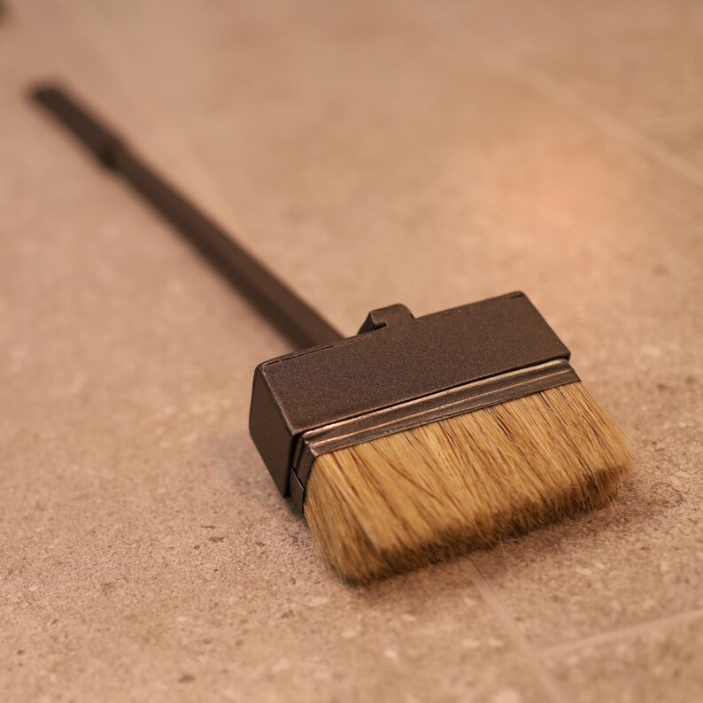 May include: A black fireplace brush with a long wooden handle and a rectangular brush head with natural bristles.