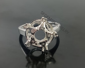 Puede incluir: Engaste de anillo de plata con una abertura redonda para la piedra central y pequeñas piedras transparentes alrededor del borde.  SFGEMSNJEWELRY está impreso en la banda.