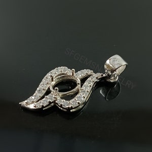 Puede incluir: Pendiente de plata con un engaste en forma de l&aacute;grima rodeado de piedras transparentes. El pendiente tiene un aro para sujetarlo a una cadena.