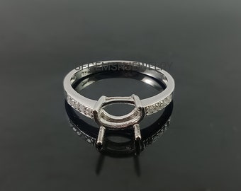 May include: A silver ring with a prong setting for a center stone and a row of small diamonds on each side of the band.