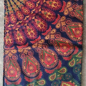 Könnte beinhalten: Ein blauer Stoff mit einem roten, gelben und grünen Paisley-Muster. Der Stoff hat ein Mandala-Design in der Mitte.