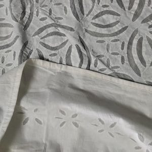 May include: White fabric with a gray pattern of curved lines and small dots. The fabric is folded in half, showing the pattern on both sides.