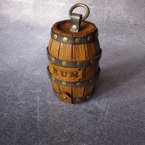 May include: A brown leather rum barrel with metal accents and the word "RUM" embossed on the front.