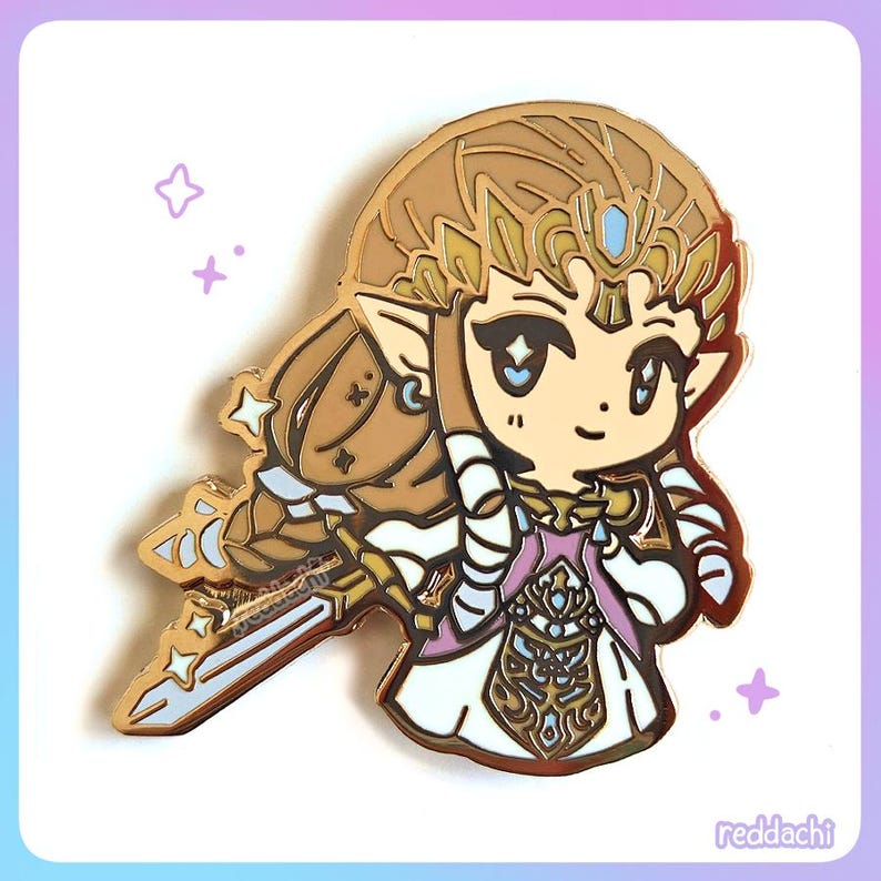 May include: A gold-colored enamel pin featuring a chibi-style illustration of a character with long, flowing hair, a crown, and a sword. The character is wearing a white and pink dress. The pin has a shiny finish and is set against a white and purple background.