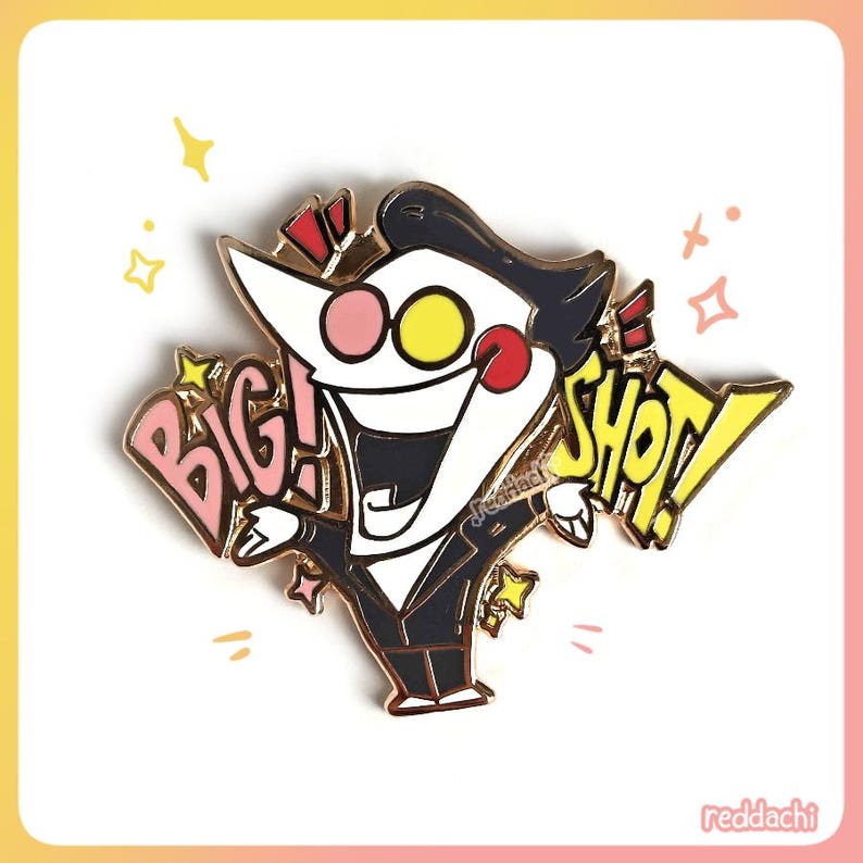May include: Enamel pin featuring a cartoon character in a black suit with a white face, pink nose, and yellow eyes. The pin has the words "BIG! SHOT!" in pink and yellow speech bubbles. The pin is surrounded by gold stars.