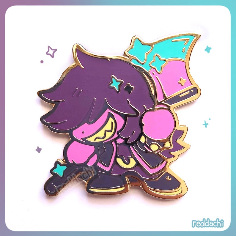 May include: A purple and pink enamel pin featuring a cartoon character with a gold outline. The character has a spiky hairstyle, a wide grin, and is holding a pink and teal flag. The pin has a gold border and the text "redddachi".