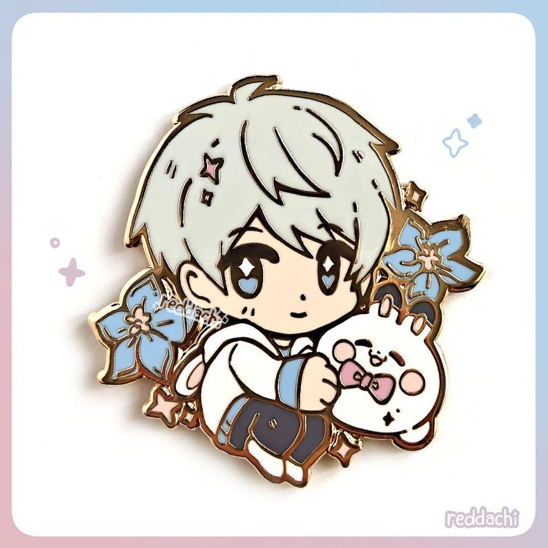 Peut inclure: &Eacute;pingle en &eacute;mail dor&eacute;e repr&eacute;sentant un personnage de dessin anim&eacute; aux cheveux gris clair, tenant une peluche blanche avec un n&oelig;ud rose. L'&eacute;pingle est orn&eacute;e de fleurs bleues et d'&eacute;toiles. Le texte "reddachi" est visible.