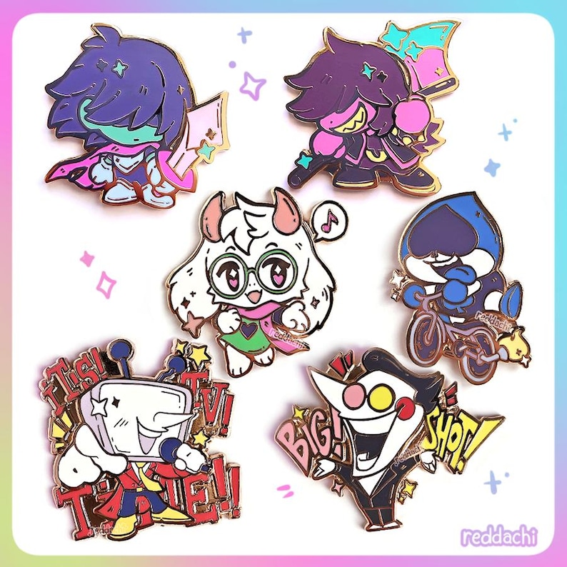 May include: A collection of colorful enamel pins featuring characters from a video game. The pins showcase various characters in dynamic poses, with vibrant colors and detailed designs. Some pins include text like "BIG SHOT!" and "IT'S TV TIME!"