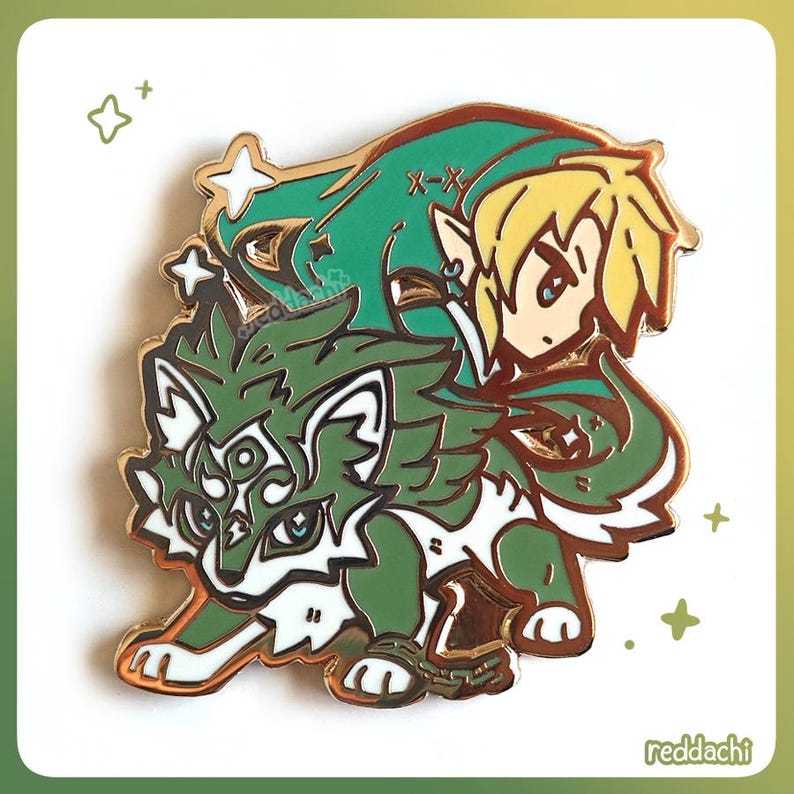 May include: A gold-colored enamel pin featuring a green wolf and a blonde-haired character with a green hat. The wolf has white accents and a chain around its front legs. The pin has a shiny finish and is set against a white background.