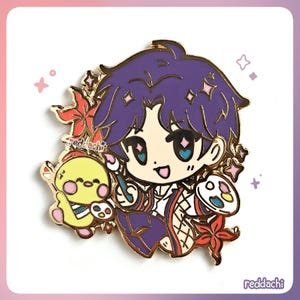 Peut inclure: &Eacute;pingle en &eacute;mail dor&eacute;e repr&eacute;sentant un personnage de dessin anim&eacute; aux cheveux violets, tenant un pinceau et une palette. Un poussin jaune avec une palette est &agrave; gauche. Des accents floraux rouges et roses entourent le personnage. Le texte "reddachi" est en bas.