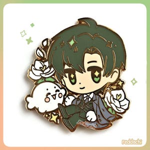 Peut inclure: &Eacute;pingle en &eacute;mail dor&eacute;e repr&eacute;sentant un personnage de dessin anim&eacute; aux cheveux verts et un costume sombre, accompagn&eacute; d'un fant&ocirc;me blanc et de fleurs blanches. L'&eacute;pingle porte le texte "redddachi".