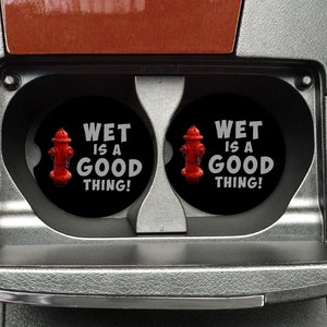 May include: Two black round coasters with a red fire hydrant graphic and the text "Wet is a good thing!" in white.