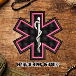 May include: Embroidered patch featuring a black star of life design with a pink border and a white staff of Asclepius. The patch has the text "EMBROIDERED PATCHES" at the bottom. The patch is on a wooden surface.