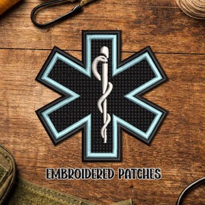 May include: Embroidered patch featuring the Star of Life, a symbol of emergency medical services. The patch has a black background with a light blue border and a white staff of Asclepius in the center. The text "EMBROIDERED PATCHES" is at the bottom.