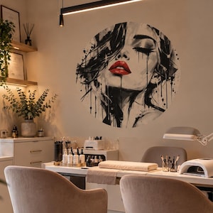 Peut inclure: Un autocollant mural circulaire représentant une illustration à l'encre noire et blanche d'un visage aux lèvres rouges éclatantes, dans un salon avec deux chaises beiges, un bureau blanc et des étagères remplies de flacons.