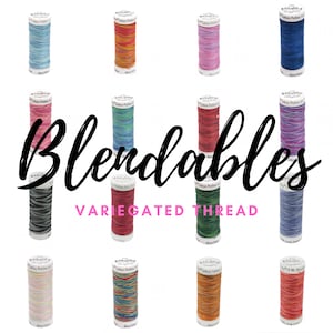 May include: A collection of 12 spools of variegated cotton thread, labeled "Blendables Variegated Thread". The spools are arranged in a circle, with each spool featuring a different color combination.