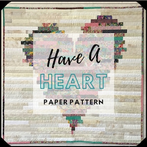 May include: A quilt pattern for a heart-shaped quilt with the text "Have A HEART PAPER PATTERN". The heart is made of colorful fabric squares.
