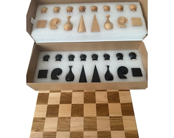 May include: A wooden chess set with a light brown and dark brown checkered board. The chess pieces are stored in a cardboard box with a foam insert. The pieces are light brown and black, with various shapes including cones, vases, and rounded tops.