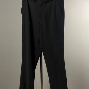 May include: Black tailored trousers with a straight leg and a waistband.