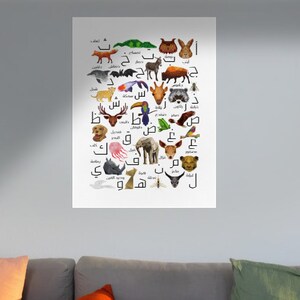 Puede incluir: Un gráfico del alfabeto que presenta ilustraciones de animales para cada letra del alfabeto árabe. Los animales están representados en un estilo de dibujos animados y están dispuestos en una cuadrícula. El gráfico está impreso en papel blanco.