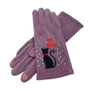 Könnte beinhalten: Lilafarbene Handschuhe mit einer schwarzen Katze und roten Herzen, die auf der Rückseite gestickt sind. Die Handschuhe haben ein weißes Punkte-Muster.