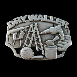 Op de afbeelding: Zilveren gesp met de woorden "Dry Waller" en afbeeldingen van gereedschap, waaronder een ladder, een boormachine, een plamuurmes en een verfroller.