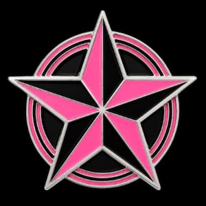 May include: A metal enamel pin featuring a five-pointed star design with alternating black and bright pink segments. The star is centered within a circular frame that has concentric rings, all outlined in a polished silver-toned metal finish.
