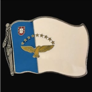 May include: A metal pin featuring the flag of the Azores, a Portuguese autonomous region. The flag is blue and white with a gold bird and stars.