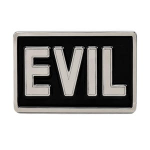 May include: A rectangular pin badge featuring the word "EVIL" in silver lettering against a black backdrop. The badge has a silver frame. The design is striking and minimalist.