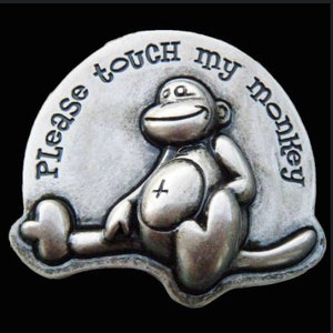 May include: A silver-toned metal charm with a monkey design and the text "Please touch my monkey".