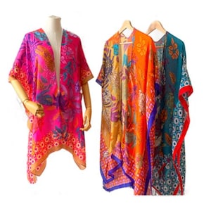 Può includere: Tre copricostumi a kimono colorati e fantasia. Il primo, su un manichino, è rosa acceso con disegni floreali. Gli altri due sono appesi, uno arancione con motivi blu e gialli, e l'altro turchese con finiture rosse.
