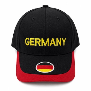 May include: Black baseball cap with the word "GERMANY" embroidered in yellow. The red brim features a small German flag patch. A stylish, sporty accessory.