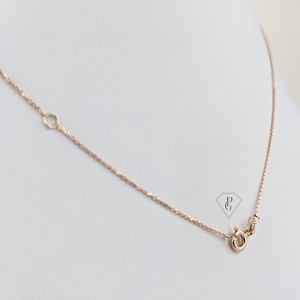 Op de afbeelding: Een delicate gouden ketting met een kreeftensluiting. De ketting is gemaakt van een fijne, gedraaide draad.