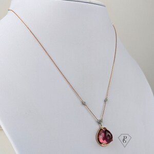 Op de afbeelding: Een ketting van ros&eacute;goud met een hanger van roze edelsteen en kleine diamant accenten. De hanger is gezet in een gouden setting en heeft een delicaat, vrouwelijk ontwerp.