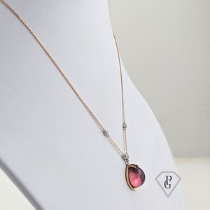 Op de afbeelding: Een delicate ketting van ros&eacute;goud met een hanger van roze edelsteen. De hanger is gezet in een ros&eacute;goud montuur en heeft een peervormige edelsteen met een subtiele glans.