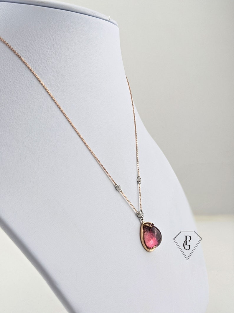 Op de afbeelding: Een delicate ketting van ros&eacute;goud met een hanger van roze edelsteen. De hanger is gezet in een ros&eacute;goud montuur en heeft een peervormige edelsteen met een subtiele glans.