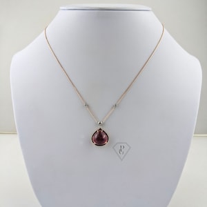Op de afbeelding: Een delicate ketting van ros&eacute;goud met een traanvormige hanger met een roze edelsteen in een gouden zetting. De hanger is versierd met kleine diamanten.