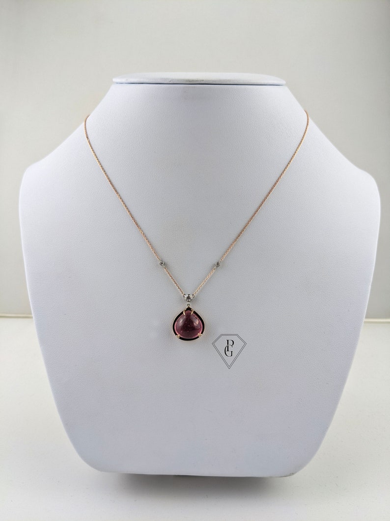 Op de afbeelding: Een delicate ketting van ros&eacute;goud met een traanvormige hanger met een roze edelsteen in een gouden zetting. De hanger is versierd met kleine diamanten.