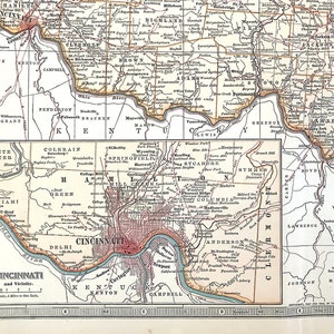 Puede incluir: Un mapa vintage detallado de Cincinnati y sus alrededores, con un centro de la ciudad en tonos rojos y los condados circundantes. El mapa incluye ríos, carreteras y nombres de ciudades, a escala de 1 milla por pulgada.