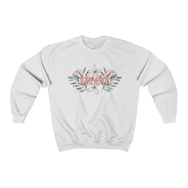 Pu&ograve; includere: Felpa bianca con la scritta "tired" in corallo, circondata da un design floreale con fiori rosa e bianchi e foglie verdi. La felpa &egrave; realizzata in un materiale morbido.