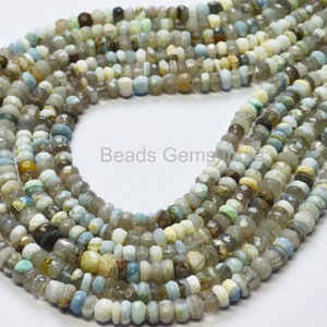 Könnte beinhalten: Mehrere Stränge facettierter Edelsteinperlen in Grau-, Weiß- und Blautönen. Die Perlen sind klein und gleichmäßig geformt, mit einer leicht unregelmäßigen Form. Der Text "Beads Gems" ist sichtbar.