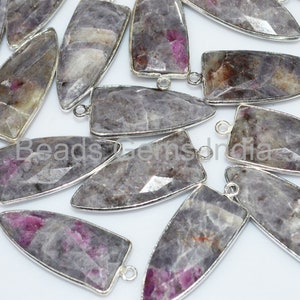 May include: A group of 15 silver-toned pendant charms with a pointed, rectangular shape. Each charm is made of a gray and pink gemstone with a silver-toned bail.