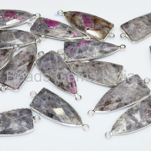 May include: A group of 16 silver-toned pendant connectors with a gray and pink gemstone. The connectors are in the shape of a teardrop with a flat back and a loop at the top.