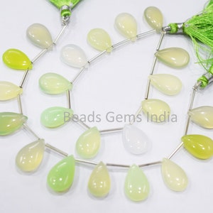 Puede incluir: Una hebra de cuentas de piedras preciosas verdes, blancas y amarillas en forma de lágrima. Las cuentas están enhebradas en alambre plateado y tienen un borla al final.